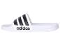 Bílé Adidas pantofle se třemi černými proužky.