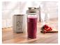 Smoothie mixér SilverCrest s lahví plnou ovocného smoothie a čerstvým ovocem na dřevěném prkénku.