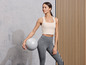 Žena v sportovním oblečení drží fit míč.