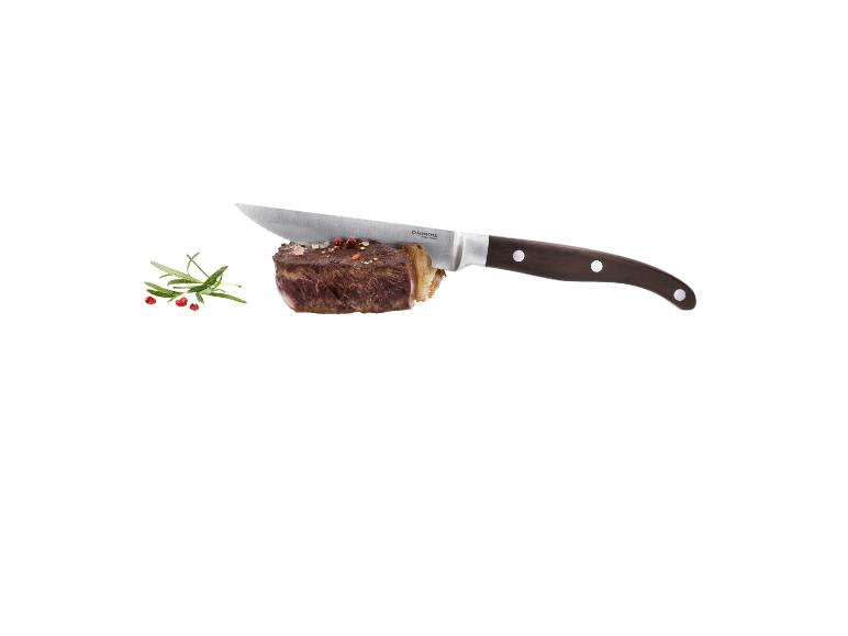 Steak s nožem, rozmarýnem a pepřem na bílém pozadí.