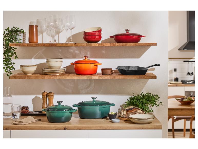 Stylová kuchyně s litinovými hrnci Le Creuset v zelené, oranžové a červené barvě.