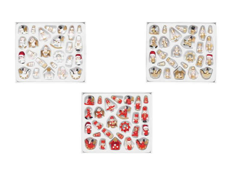 Tři sady miniaturních vánočních ozdob, včetně figurek andělů a louskáčků.