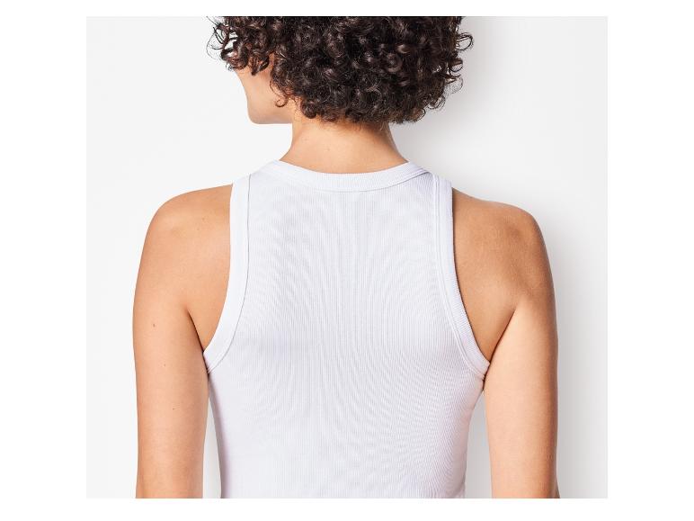 Žena má na sobě bílý tank top s racerbackem.
