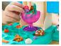 Dětské ruce si hrají s barevnou modelínou, vytvářejí tvary jako květiny a preclíky.