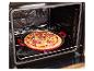 Čerstvě připravená pizza v červené pánvi, umístěná v otevřené troubě.
