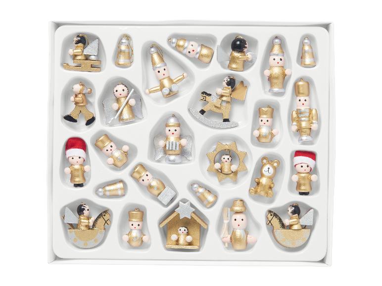 Sortiment zlatých a stříbrných dřevěných vánočních ozdob v bílé krabici.