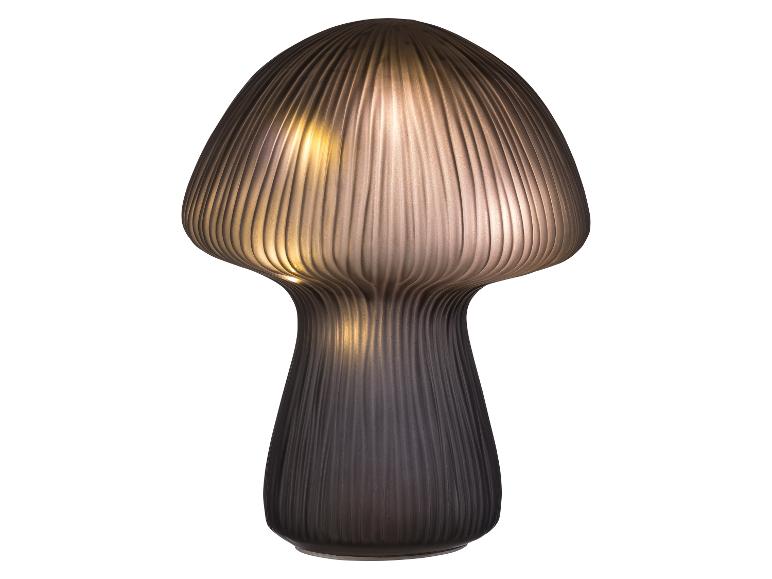 Moderní stolní lampa ve tvaru houby s žebrovaným stínítkem a teplým světlem.