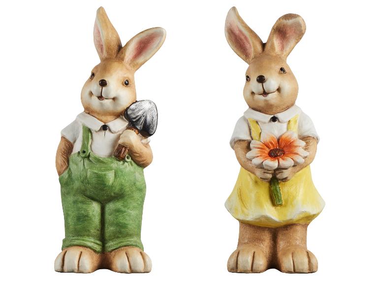Dvě keramické figurky velikonočních zajíčků, jeden s lopatou, druhý s květinou.