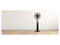 Černý stojící ventilátor s vodní nádrží na dřevěné podlaze.