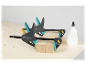 Dvě svěrky Wolfcraft na dřevěném povrchu s lahví lepidla.