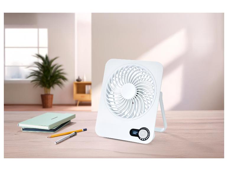 Bílý stolní ventilátor s digitálním displejem 60° na dřevěném stole s poznámkovými bloky a tužkami.