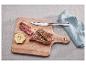 Steak s rozmarýnem, česnek a nůž SilverCrest na dřevěném prkénku.