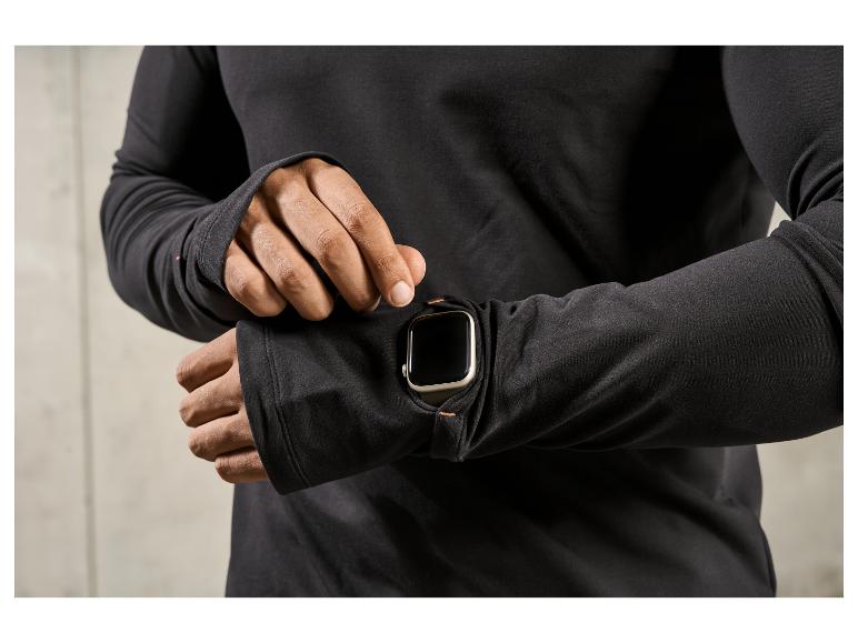 Muž v černém svetru s Apple Watch na ruce.