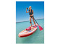 Žena pádluje na růžovém nafukovacím paddleboardu v tyrkysové vodě.