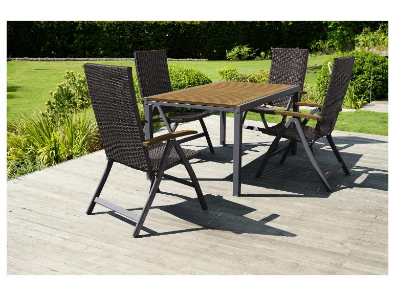 Zahradní nábytek se stolem a čtyřmi židlemi na dřevěné terase.