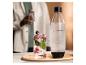 Láhev SodaStream a sklenice perlivého nápoje s bobulemi a mátou.