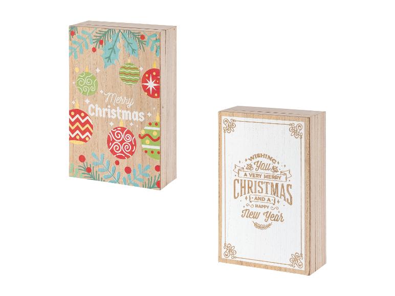 Dvě dřevěné cedule s vánočními motivy, jedna s barevnými ozdobami a druhá s textem.