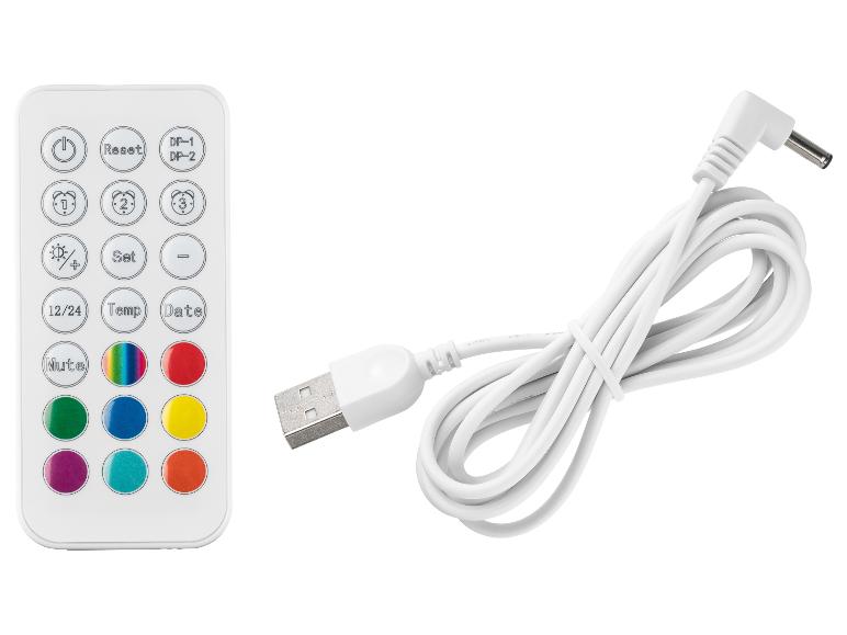 Bílý dálkový ovladač s barevnými tlačítky a USB nabíjecím kabelem.