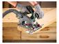 Ruce v rukavicích používají okružní pilu PARKSIDE k řezání dřevěné desky.