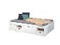 Bílá postel s integrovaným úložným prostorem, šedou matrací a barevnými polštáři.
