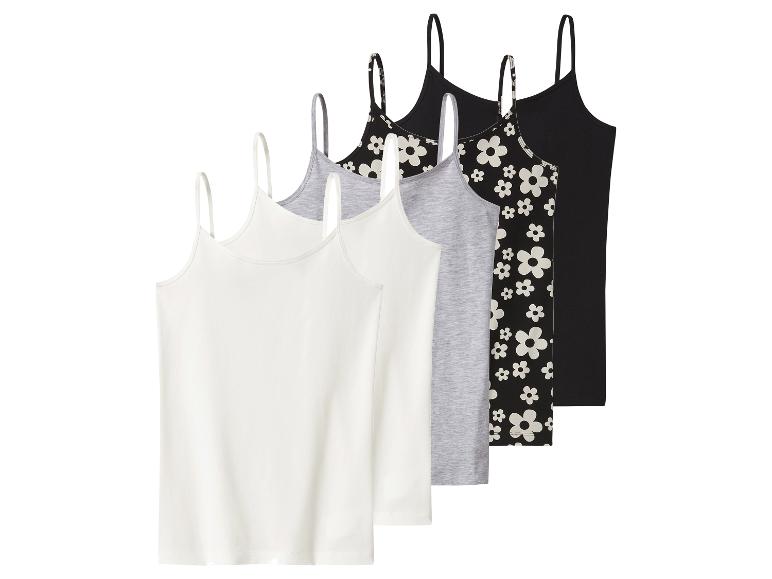 Sada pěti tílek: dvě bílá, jedno šedé, jedno černé s květinami a jedno obyčejné černé.