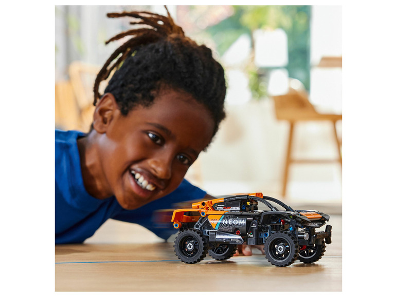 Dítě si hraje s terénním autem LEGO Technic.