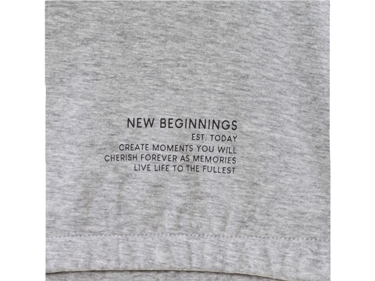 Šedé tričko s nápisem 'New Beginnings' a motivačním citátem.