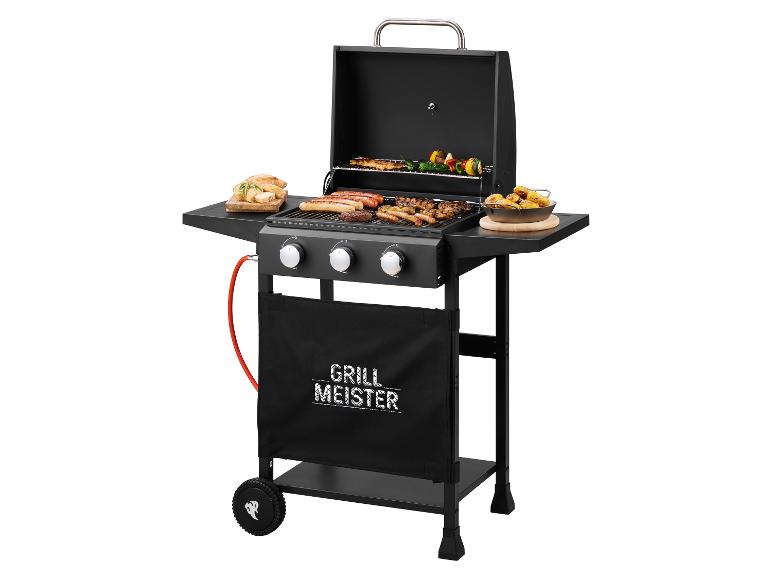 Plynový gril Grill Meister s klobásami, špízy a pečenými bramborami.