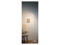 Moderní bílá LED stojací lampa u křesla.