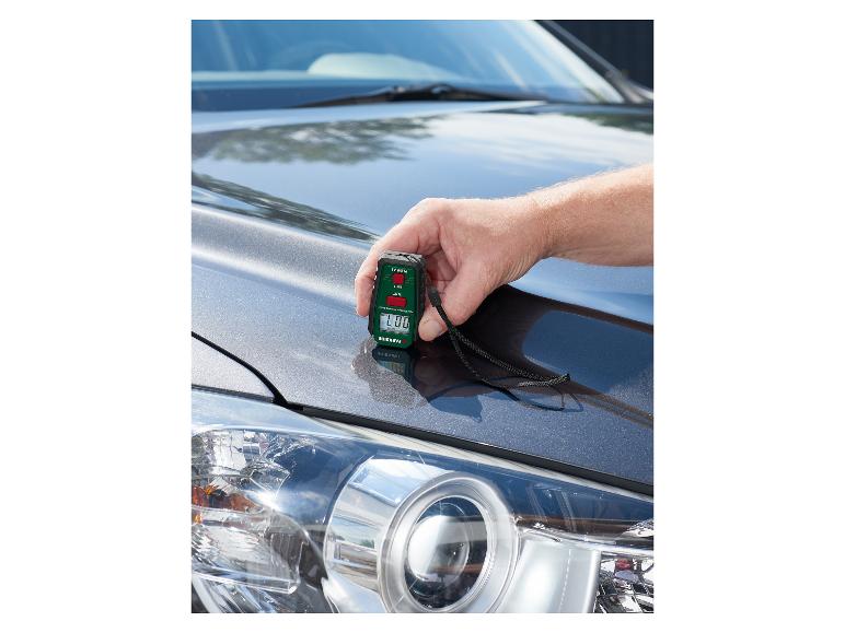 Muž používá měřič tloušťky laku PARKSIDE na kapotě auta.