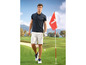 Muž v golfovém oblečení s holí na golfovém hřišti.