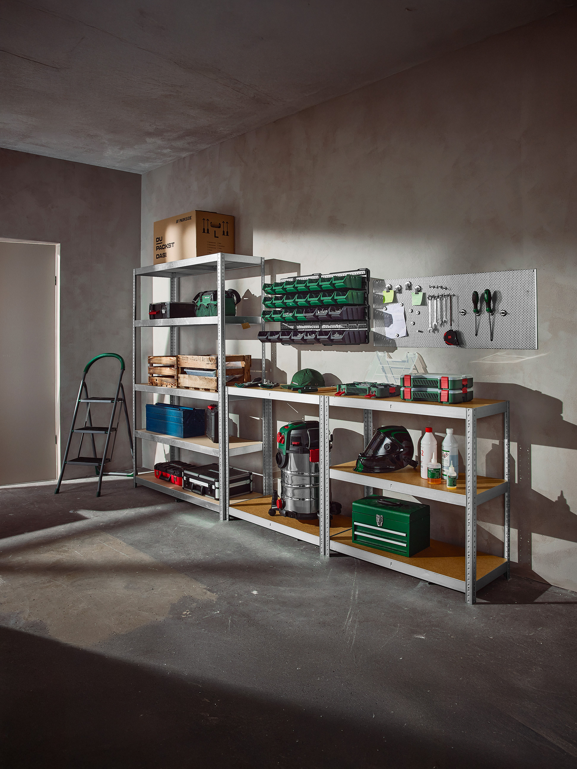 Organizovaná garáž s regály plnými nářadí, úložných boxů a dílenského vybavení.