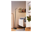 Černá stojací lampa s ohnutým ramenem osvětluje moderní obývací pokoj.