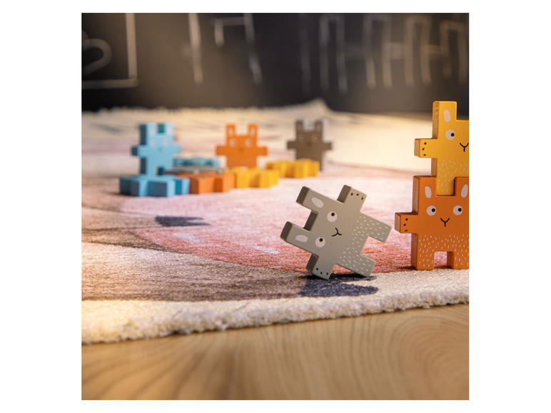 Dřevěné puzzle s motivem zvířátek na koberci.