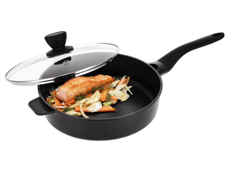Černá pánev se skleněnou poklicí, obsahující lososa a zeleninu.