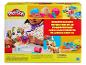 Sada Play-Doh Pretend Pet Play s dítětem hrajícím si na veterináře s figurkou psa a barevnou modelínou.