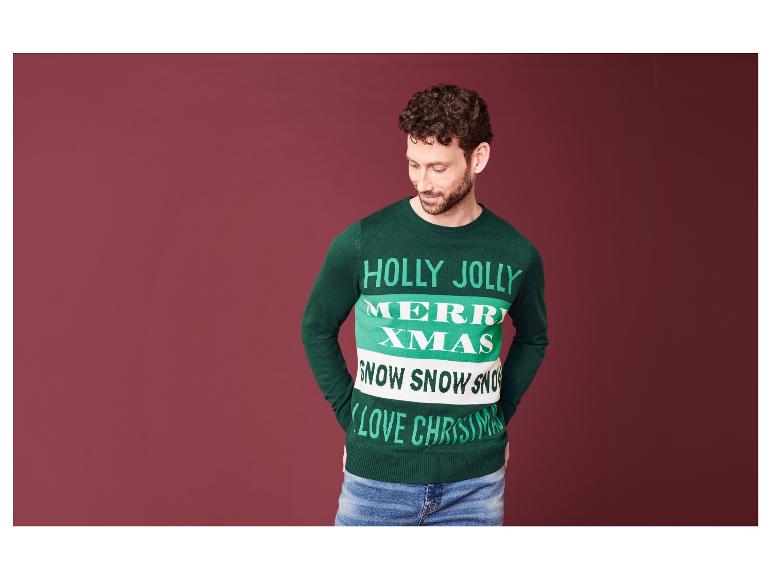 Muž v zeleném vánočním svetru s nápisem 'Holly Jolly Merry Xmas'