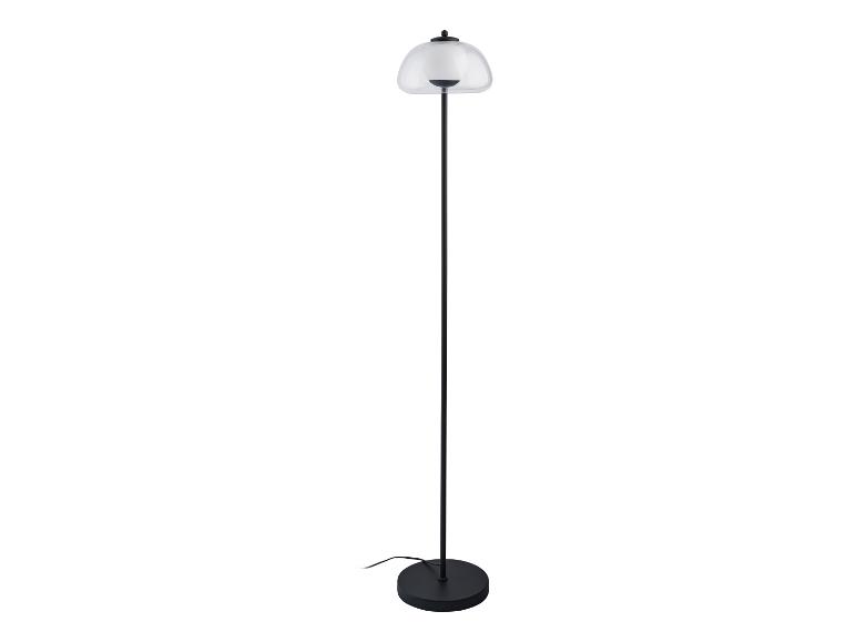 Moderní stojací lampa s průhledným skleněným stínítkem.