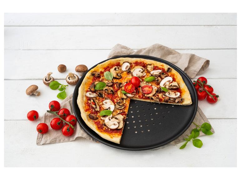 Pizza s houbami a cherry rajčaty na pekáči.
