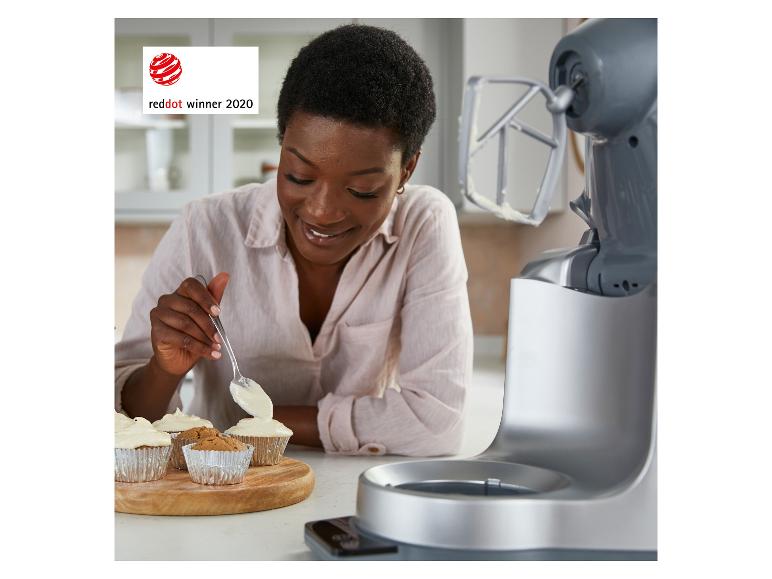 Žena zdobí muffiny, vedle stojí kuchyňský robot. Ocenění Red Dot 2020.