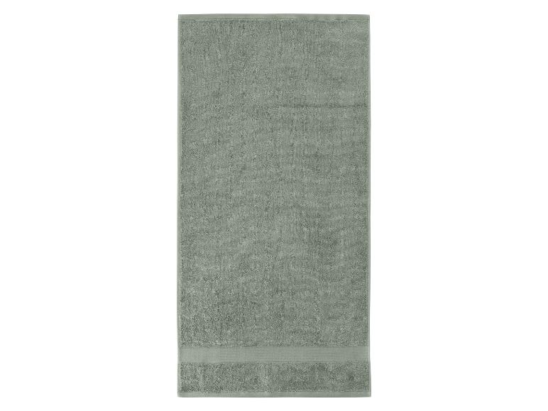 Šedozelený ručník s pruhovaným okrajem.