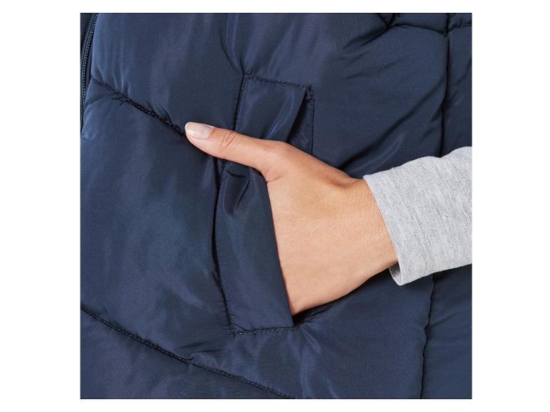 Detailní snímek modré zimní bundy s rukou v kapse.