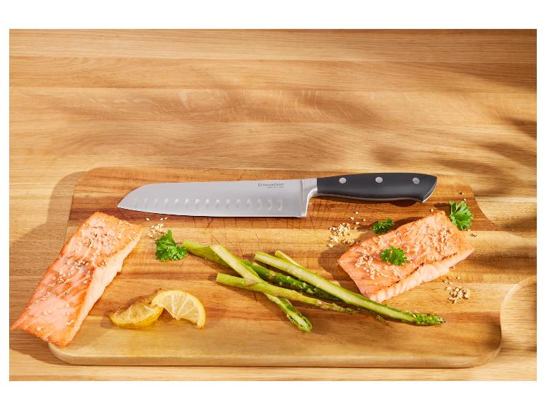 Losos, chřest a nůž SilverCrest na dřevěné desce.