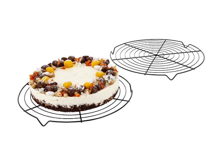 Cheesecake s čokoládou, ořechy a ovocnými dekoracemi na chladicí mřížce.