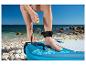 Paddleboard a bezpečnostní leash na slunné pláži.
