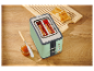 Retro toustovač Smeg v mentolové zelené barvě s opečeným chlebem a marmeládou.