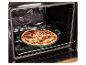 Čerstvě připravená pizza v zelené pečicí pánvi, umístěná na roštu v otevřené troubě.