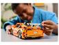 Dítě skládá oranžové auto LEGO Technic Fast & Furious.
