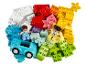 Hromada barevných kostek LEGO DUPLO se dvěma figurkami a autem.