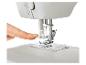 Ruka nastavuje patku na bílém šicím stroji.